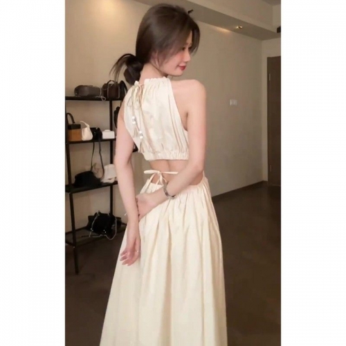 A chic, French-inspired sleeveless halter-neck dress with a backless design and tie detailing, exuding a gentle and elegant charm.