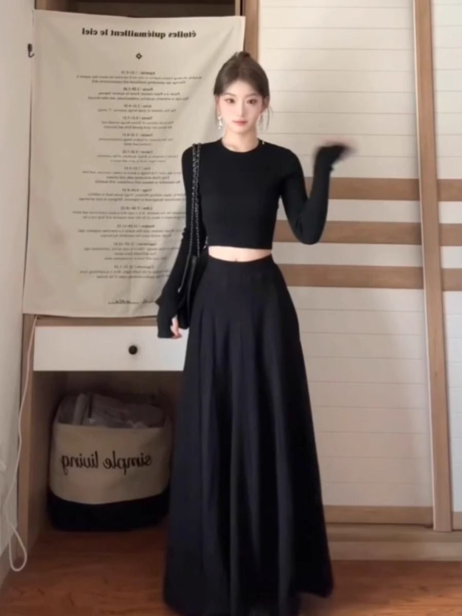 A petite woman wearing a matching long dress exudes a sophisticated and beautiful early autumn vibe with this black Hepburn-inspired dress, perfect for a youthful and age-defying look.