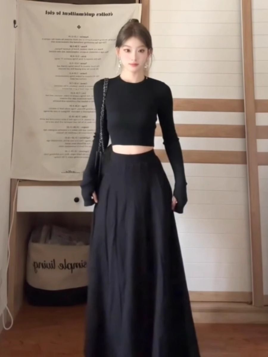 A petite woman wearing a matching long dress exudes a sophisticated and beautiful early autumn vibe with this black Hepburn-inspired dress, perfect for a youthful and age-defying look.