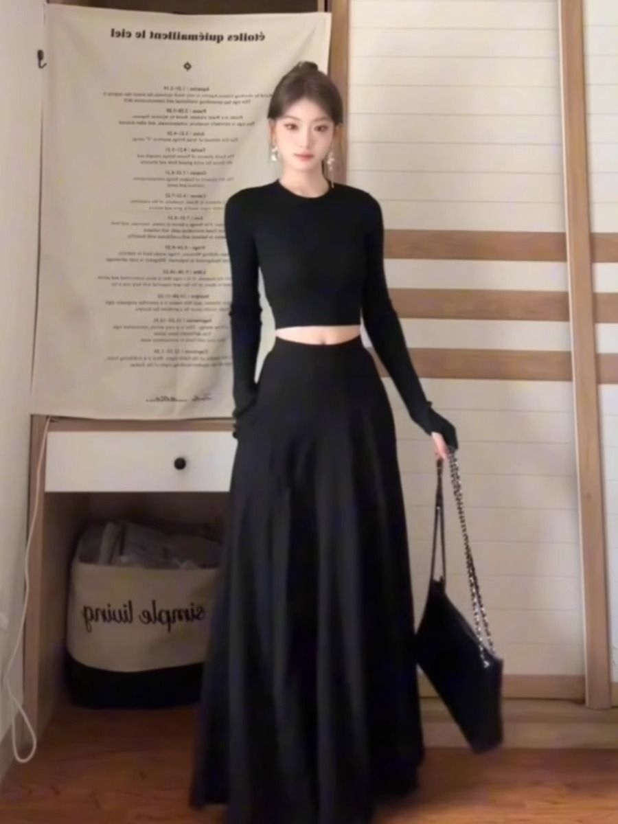 A petite woman wearing a matching long dress exudes a sophisticated and beautiful early autumn vibe with this black Hepburn-inspired dress, perfect for a youthful and age-defying look.