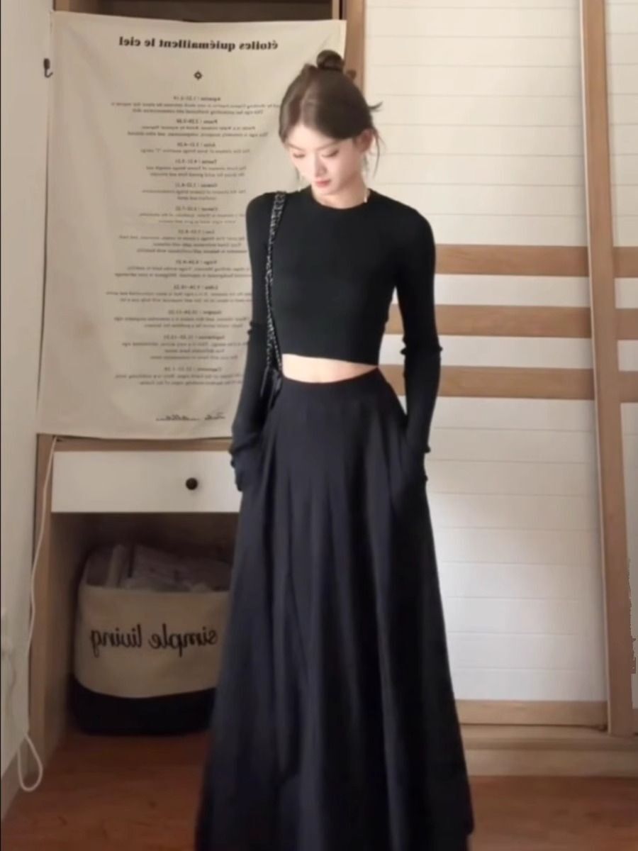 A petite woman wearing a matching long dress exudes a sophisticated and beautiful early autumn vibe with this black Hepburn-inspired dress, perfect for a youthful and age-defying look.